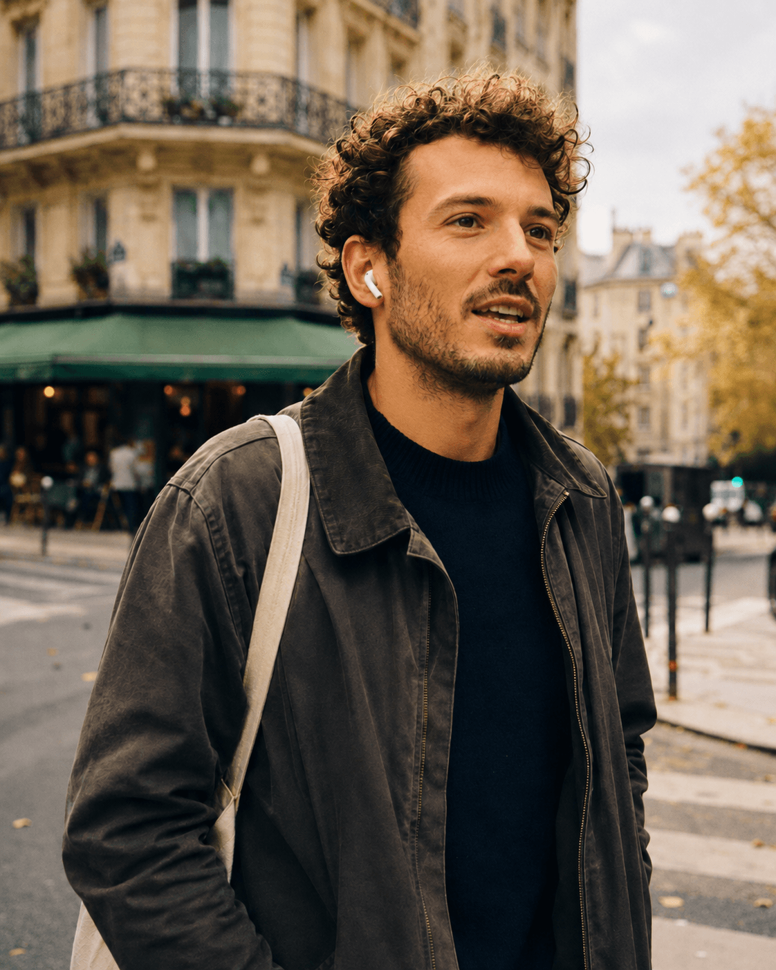 Person walking in a city street with an earbud in, practicing French aloud