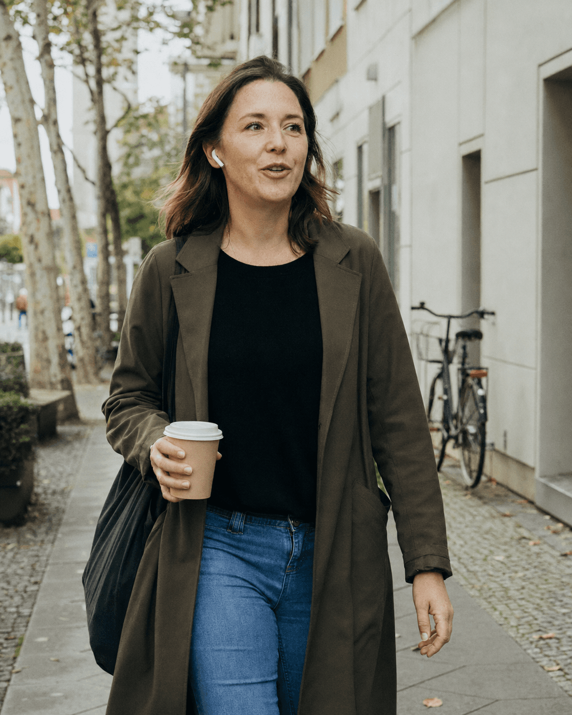 Person outdoors wearing headphones, speaking German out loud